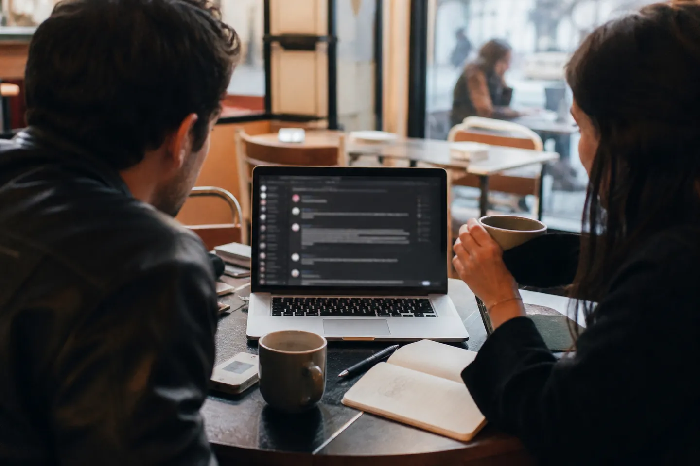 A user engages in a deep web discussion at a cafe table.